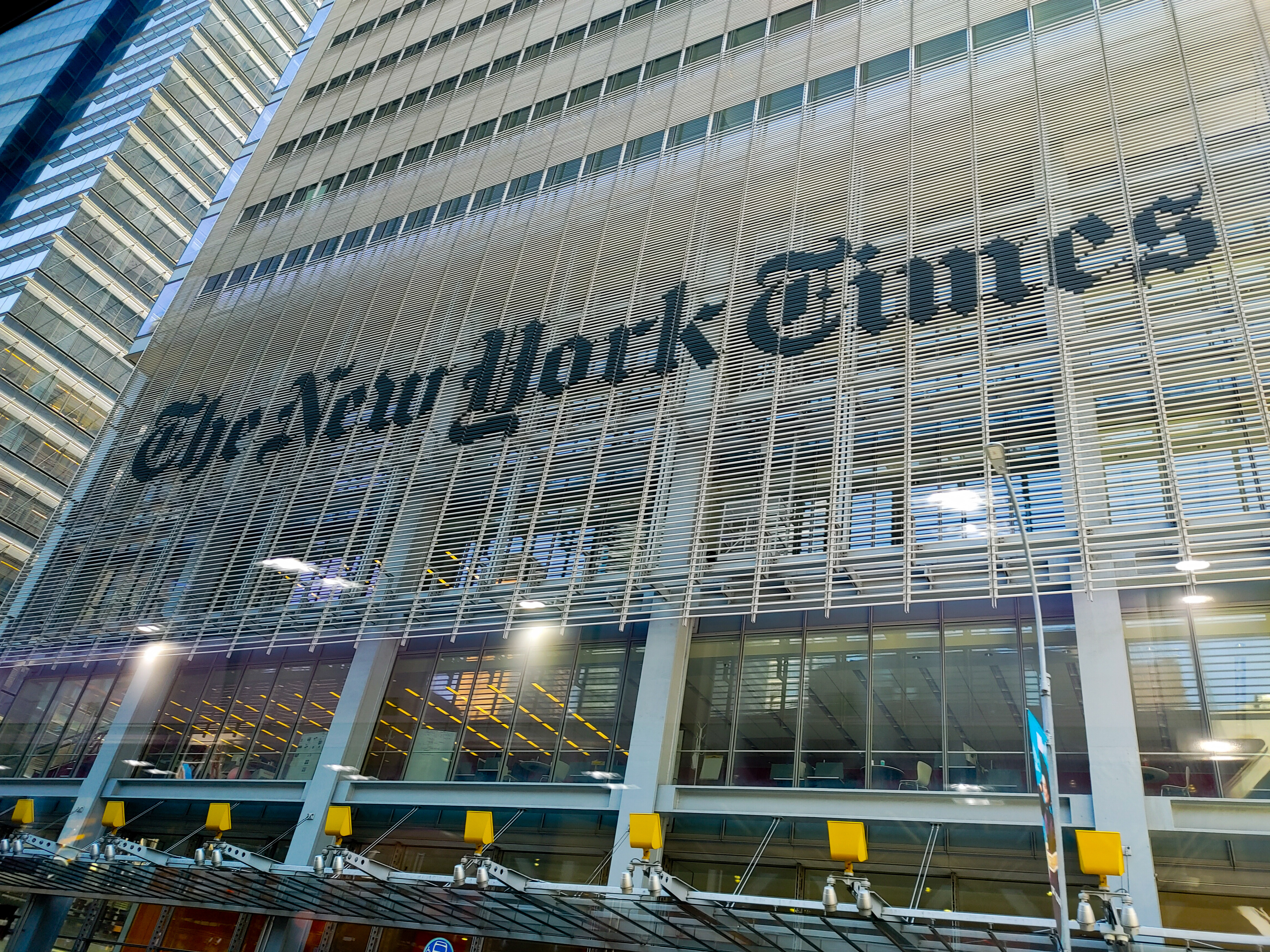The New York Times name spanning the metal screen of its Manhattan building